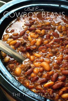 a slow cooker filled with chili beans and topped with a spoon in the bowl