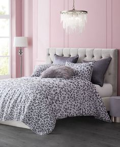 a bedroom with pink walls and leopard print bedding