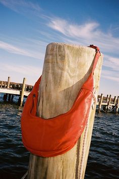 an orange purse sitting on top of a wooden post