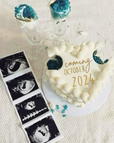 a heart shaped cake sitting on top of a table next to pictures and vases