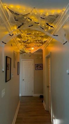 a hallway decorated for halloween with bats on the ceiling and lights hanging from the ceiling