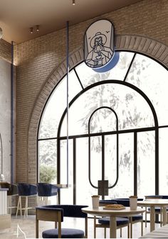 the interior of a restaurant with large arched windows and blue stools in front of it