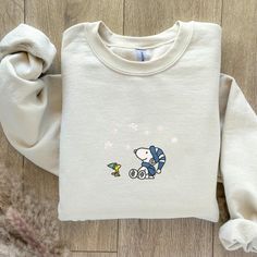 Embroidered Snoopy & Woodstock Winter Sweater | Cozy Fleece-Lined Snowfall Sweater Bring the magic of winter to your wardrobe with this charming embroidered sweater featuring Snoopy and Woodstock watching the snow gently fall. This adorable design captures the cozy, peaceful feeling of a winter wonderland, making it the perfect sweater for the colder months and holiday season. Crafted with a soft, fleece-lined interior, this sweater ensures maximum warmth and comfort, whether you're enjoying a s Winter Snoopy, Snoopy Winter, Cute Winter Sweater, Snoopy Sweatshirt, Cute Winter Sweaters, Perfect Sweater, Winter Szenen, Snoopy Woodstock, Snowy Day