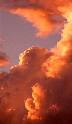 an airplane is flying in the sky with clouds behind it at sunset or sunrise time