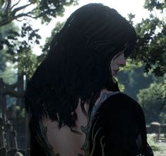 a woman with black hair and tattoos standing in front of a tree, looking off into the distance