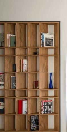 a bookshelf filled with lots of books next to a window