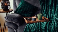 a tray with two cups on it next to a chair