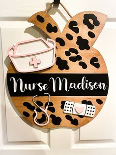 a wooden sign that says nurse madison hanging on a door with other items attached to it