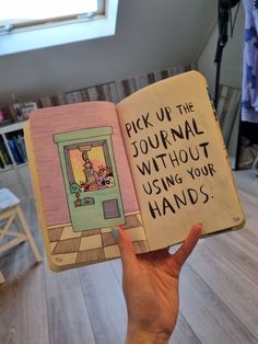 a person holding up a book with writing on the pages that read pick up the journal without using your hands