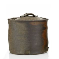 an old pot is sitting on a white surface