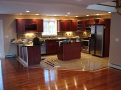 an empty kitchen and living room with hardwood floors