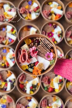 a person holding a bowl filled with different types of food in it's hands