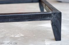 a black bench sitting on top of a cement floor