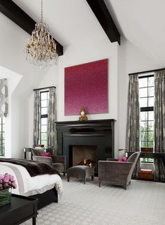 a bedroom with a fireplace and chandelier in the corner, along with two chairs