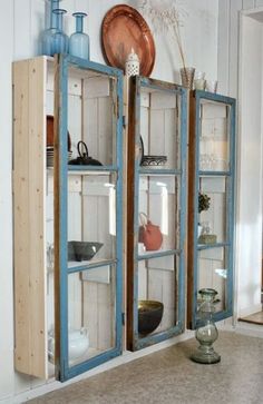 an old blue cabinet with glass doors is in the middle of a room that has white walls and flooring