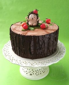 there is a cake that looks like a hedgehog sitting on top of a tree stump