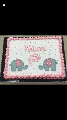 a welcome baby girl cake with two elephants on it and polka dots around the edges