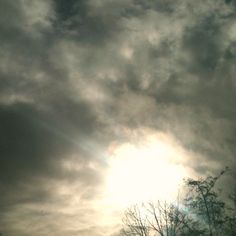 the sun is shining through some dark clouds