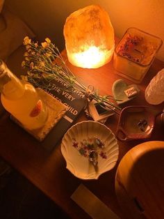 the table is cluttered with dishes and flowers on it, including a bottle of alcohol