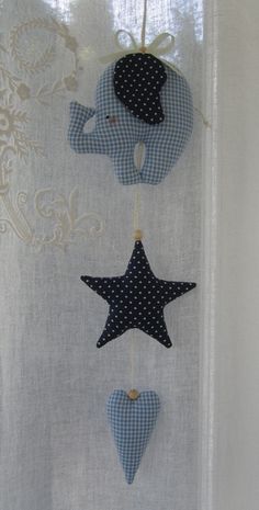 three blue and white stars hanging from the side of a curtain with an elephant on it