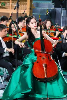 a woman in a green dress playing an instrument