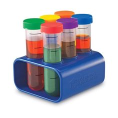 a set of six bottles filled with different colored liquids on top of a blue holder