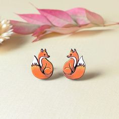 the earrings are made out of wood and have an orange fox design on it's backs