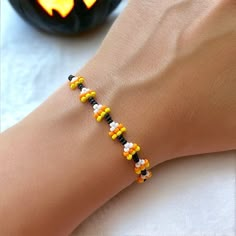 a woman's arm with a bracelet made out of beads and candy corn on it