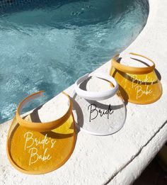 three bride's bibs next to a swimming pool