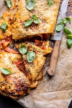 some food is laying out on a piece of parchment paper with a knife next to it