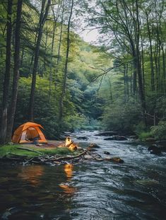 a tent set up on the bank of a river with a campfire next to it