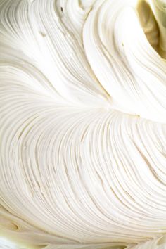 a close up view of white frosting in a bowl