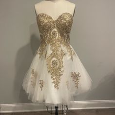 a white and gold dress on a mannequin