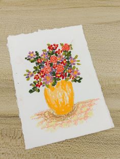 a drawing of flowers in a yellow vase on a white piece of paper with colored crayons