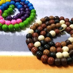 three different colored beads on a table with one bead in the shape of a circle