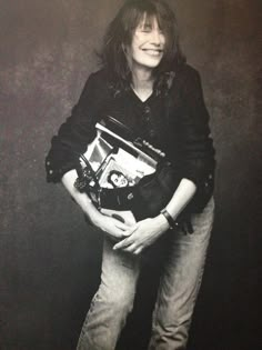 a woman is holding an open purse and smiling at the camera while posing for a black and white photo