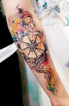 a person with a tattoo on their arm that has an image of a compass in it