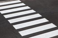 an empty street with white lines painted on the pavement and stop sign in the middle