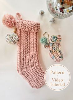 a knitted sock with pom - poms and keychain next to it