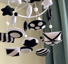 a mobile with black and white decorations hanging from it