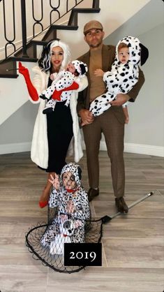 two adults and one child dressed in dalmatian costumes, standing next to each other