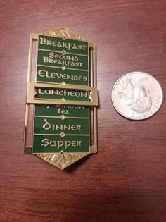 the medal for breakfast is next to a quarter penny on a wooden table with it's nameplate