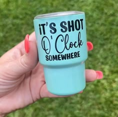 someone holding up a blue cup that says it's shot o'clock somewhere