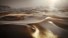 the sun shines brightly on sand dunes