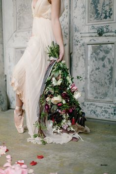 a woman in a dress holding a bouquet of flowers