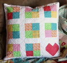 a patchwork pillow is sitting on a couch