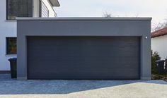 a grey garage door on the side of a house