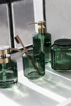 green glass bathroom accessories with toothbrush and soap dispenser