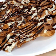 a white plate topped with waffles covered in chocolate