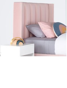 a bed with pink headboard and pillows on top of it next to a night stand